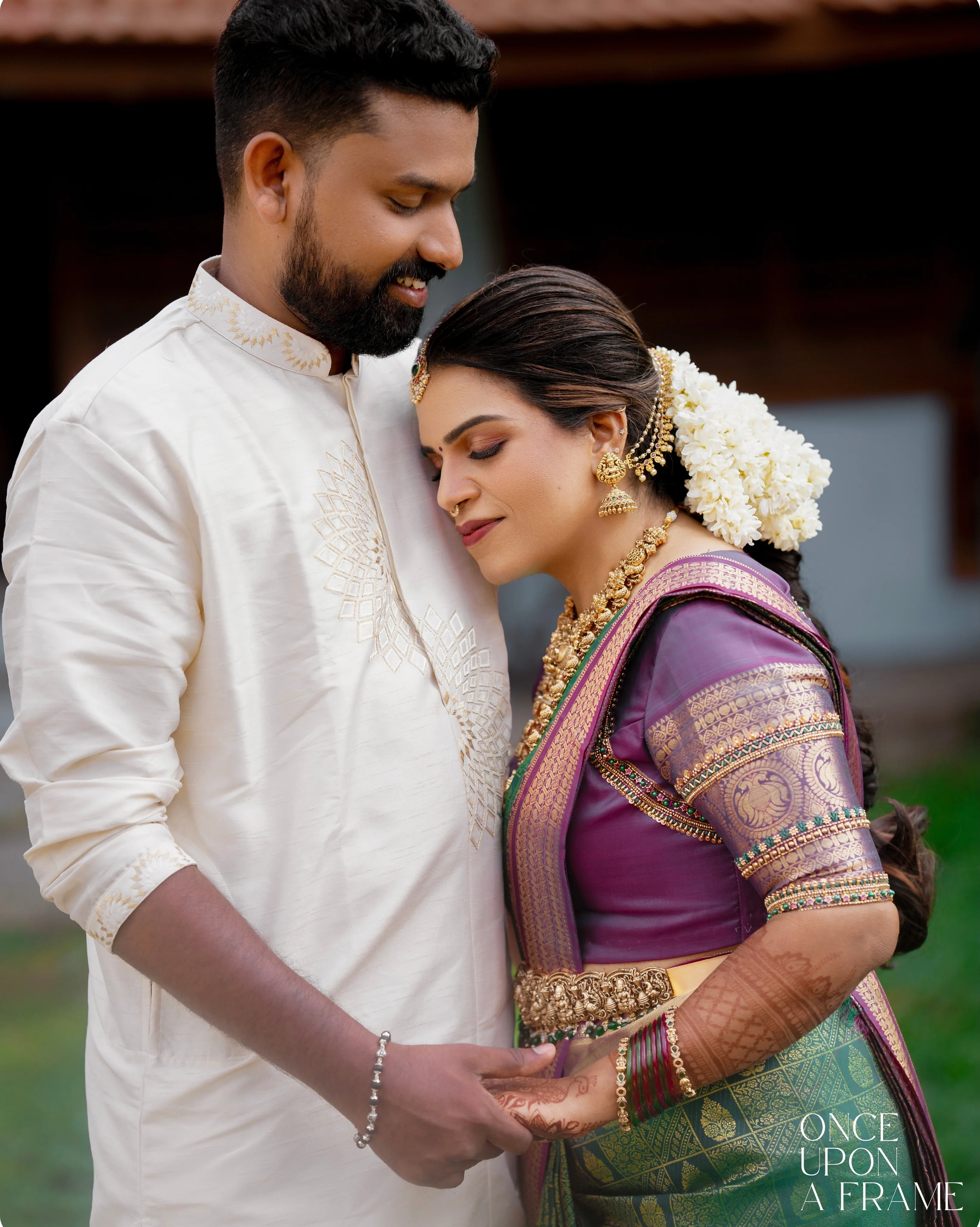 A traditionally dressed couple holding hands in a quiet embrace
